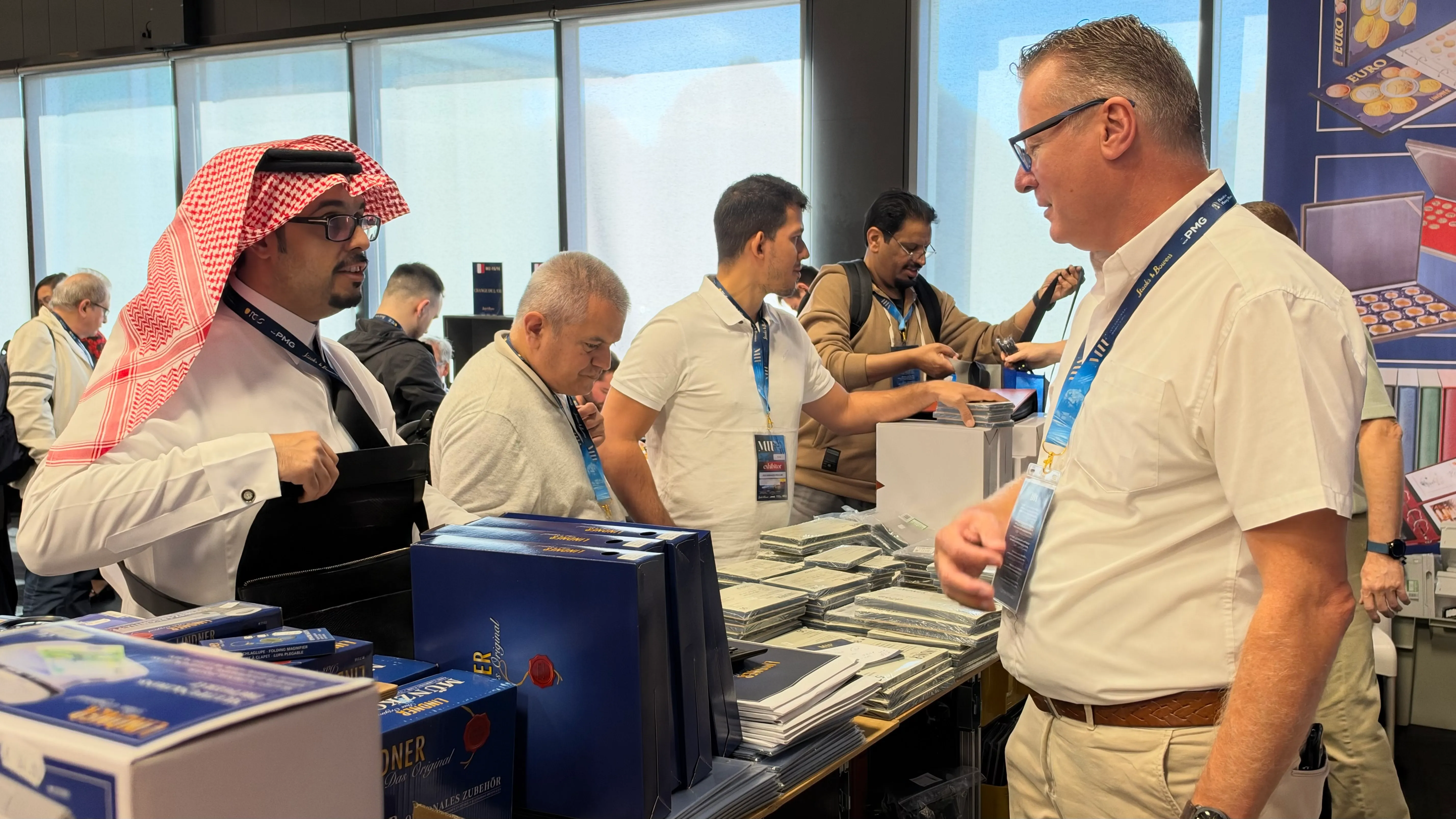 Visitors and exhibitors talking at a stand with albums and collecting accessories
