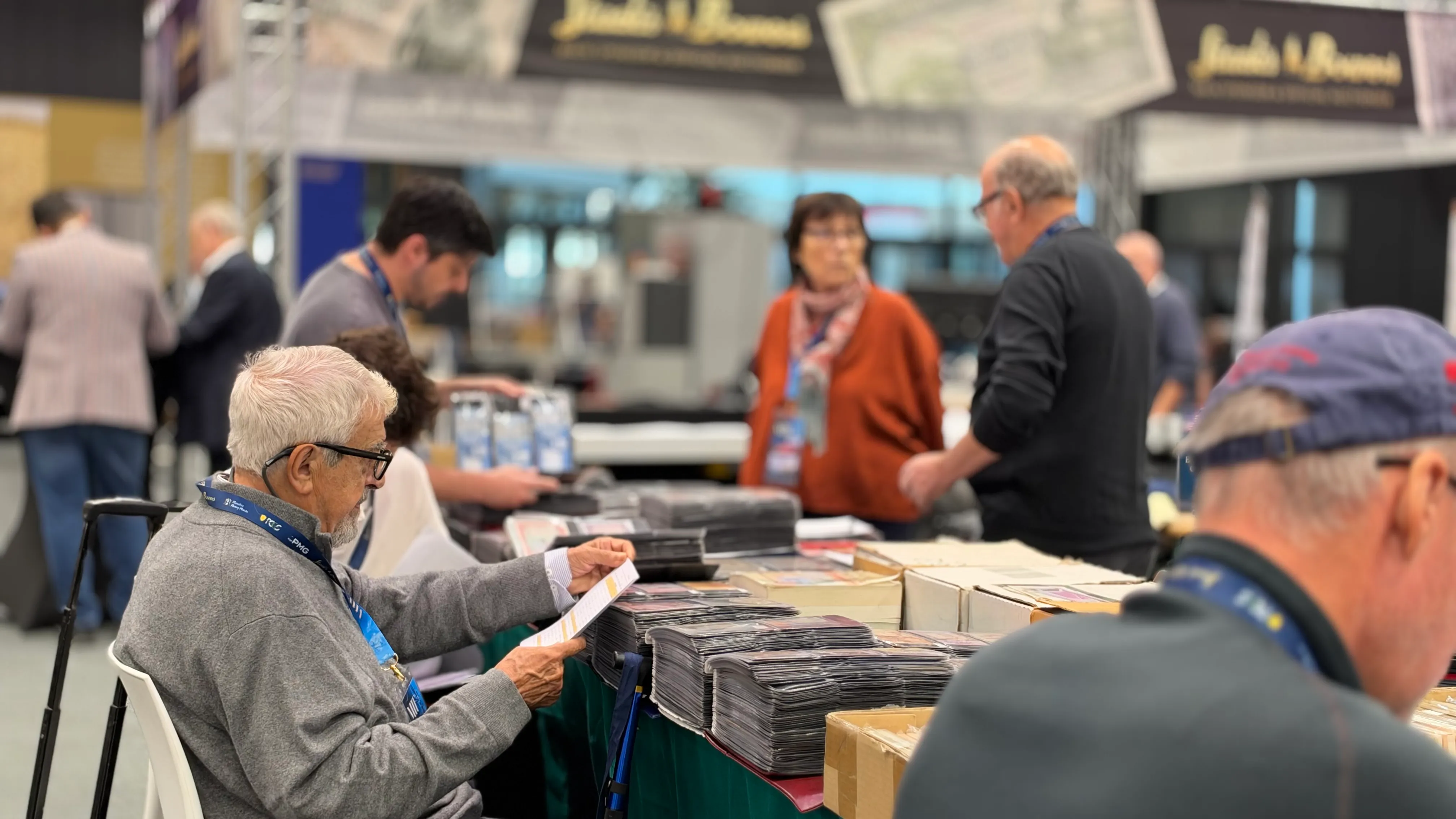 Visitor reading a list at a table stacked with banknotes in protective sleeves