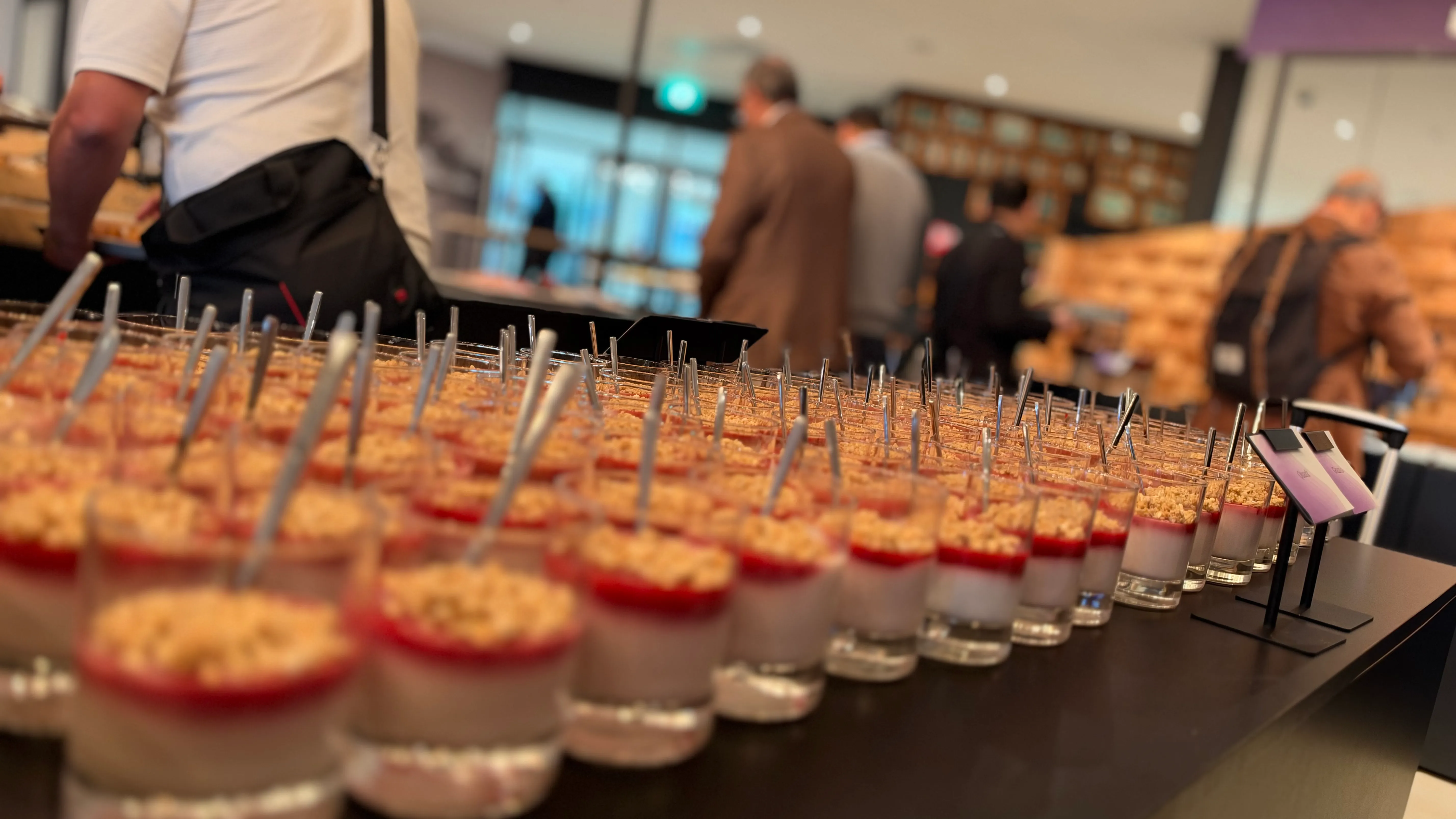 Rows of yoghurt desserts with fruit and granola at the breakfast buffet